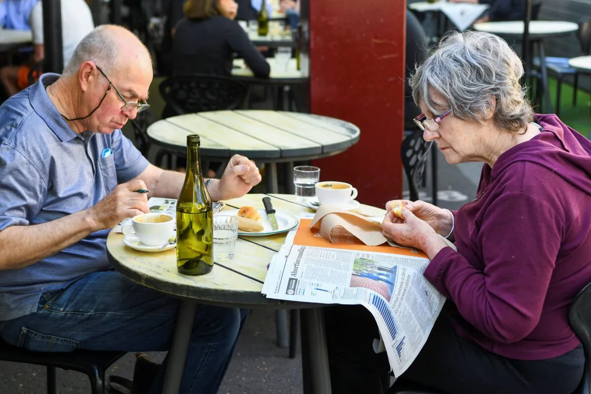 A couple enjoys breakfast at a busy Lygon Street cafe in Melbourne on Oct. 22, 2021. (William West/AFP via Getty Images)