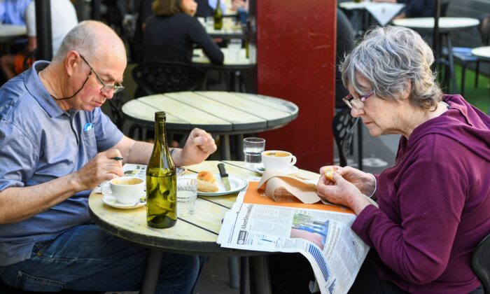 A couple enjoys breakfast at a busy Lygon Street cafe in Melbourne on Oct. 22, 2021. (William West/AFP via Getty Images)