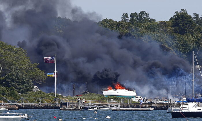 Crews battle a massive fire that has destroyed buildings, cars, and vessels at a boat yard in Mattapoisett, Mass., on Aug. 19, 2022. (Peter Pereira/The Standard-Times via AP)