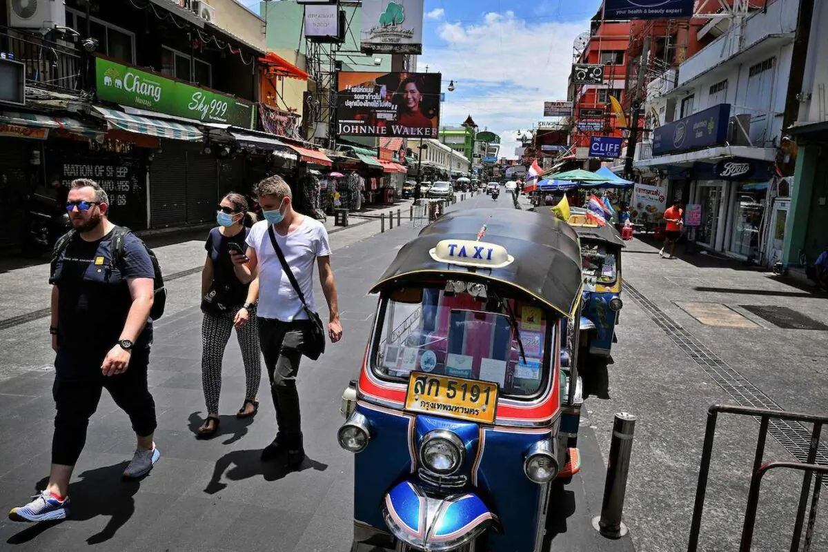 Foreign tourists walk along the popular Khaosan Road in Bangkok, Thailand, on May 17, 2022. (Lillian Suwanrumpha/AFP via Getty Images)