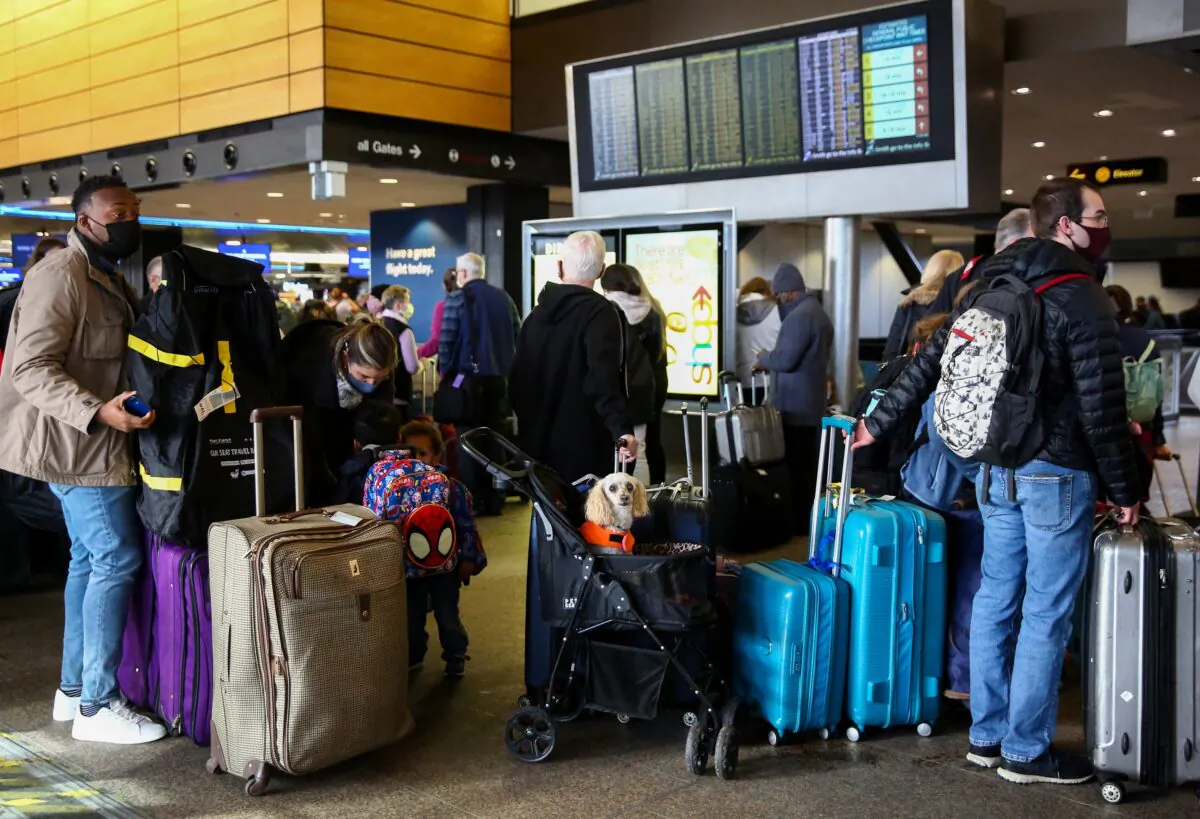 People wait in long check-in lines after dozens of flights were listed as cancelled or delayed at Seattle-Tacoma International Airport (Sea-Tac) in Seattle on Dec. 27, 2021. (Lindsey Wasson/Reuters)