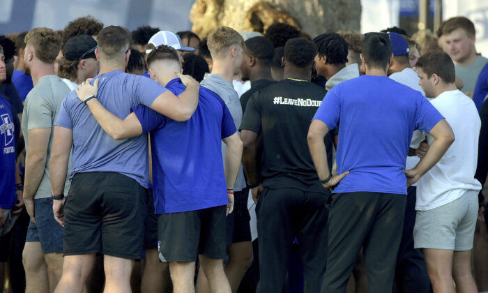 Members of the Indiana State football team console one another after a vigil at Memorial Stadium in Terre Haute, Ind., on Aug. 21, 2022, for students, including fellow football players, who were involved in a car crash earlier in the day. (Joseph C. Garza/The Tribune-Star via AP)