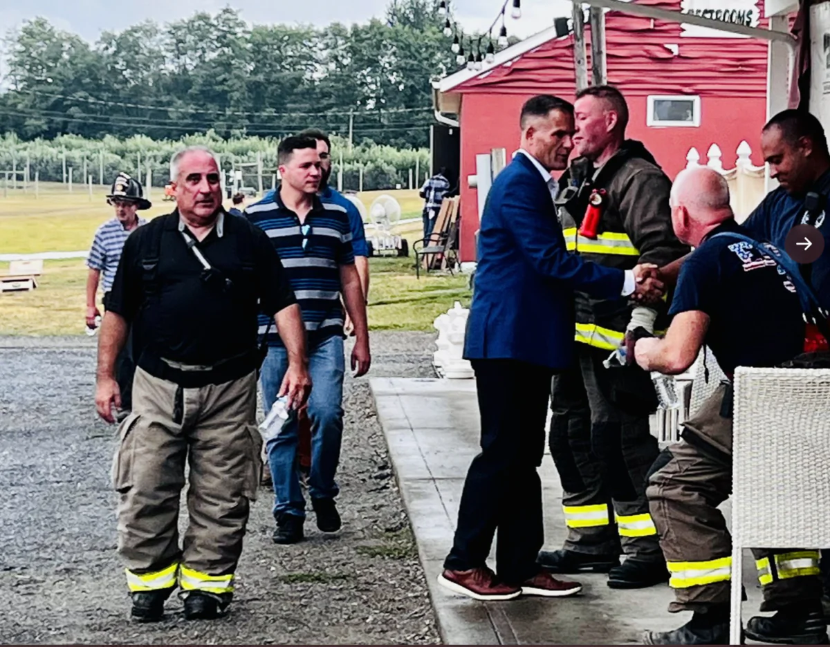 New York Congressional District 19 Aug. 23 Republican special election candidate Marc Molinaro, in suit, thanks firefighters in Beekman on Aug. 22 after they responded to a fire at Barton Orchards. (Courtesy of Molinaro for Congress)
