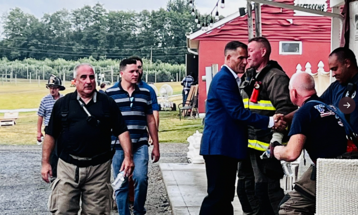 New York Congressional District 19 Aug. 23 Republican special election candidate Marc Molinaro, in suit, thanks firefighters in Beekman on Aug. 22 after they responded to a fire at Barton Orchards. (Courtesy of Molinaro for Congress)