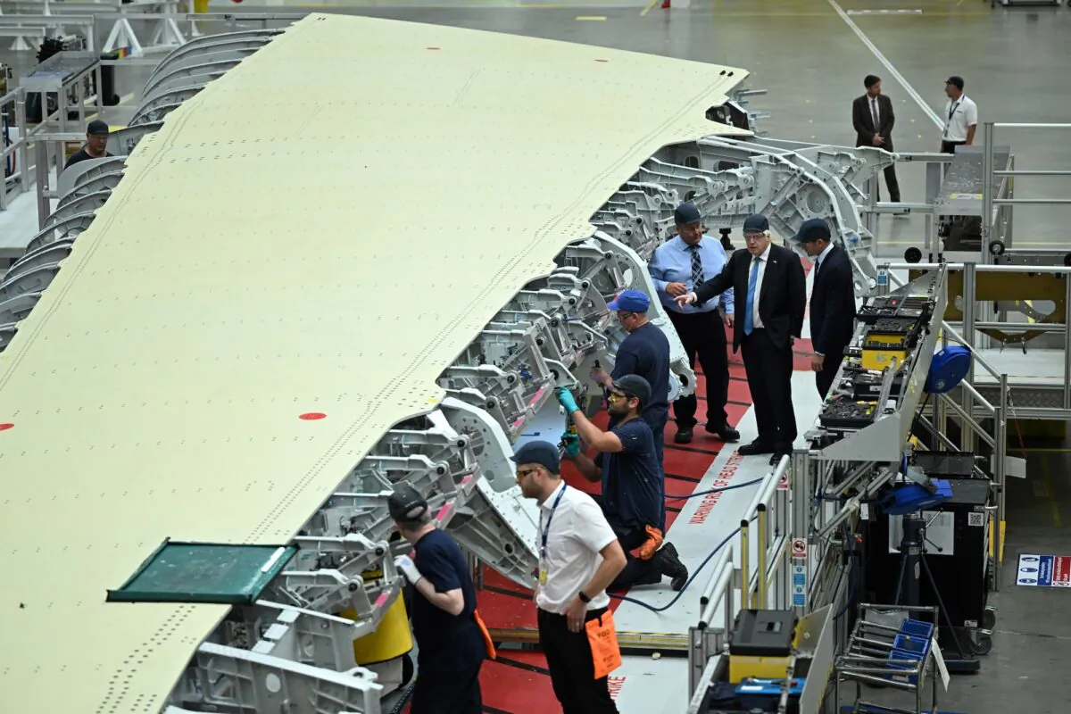 Prime Minister Boris Johnson (C), visits the division manufacturing the wings for the A350 during a tour of the Broughton Airbus plant,  on August 12, 2022 in Chester, United Kingdom. (Oli Scarff - WPA Pool/Getty Images)