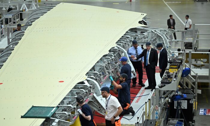 2022 年 8 月 12 日，英国切斯特，英国首相鲍里斯·约翰逊 (C) 在参观布劳顿空客工厂期间参观了 A350 机翼制造部门。  （奥利斯卡夫——WPA 游泳池/盖蒂图片社）