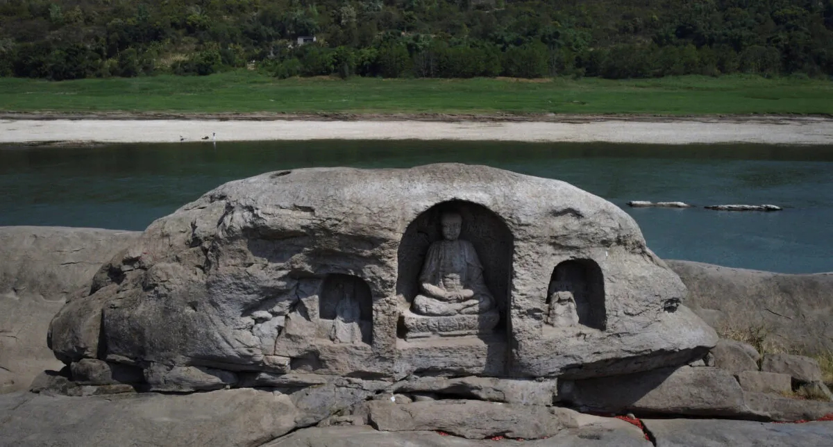 A once submerged Buddha statue sits on top of Foyeliang island reef in the Yangtze river, which appeared after water levels fell due to a regional drought in Chongqing, China, on Aug. 20, 2022. (Thomas Peter/Reuters)