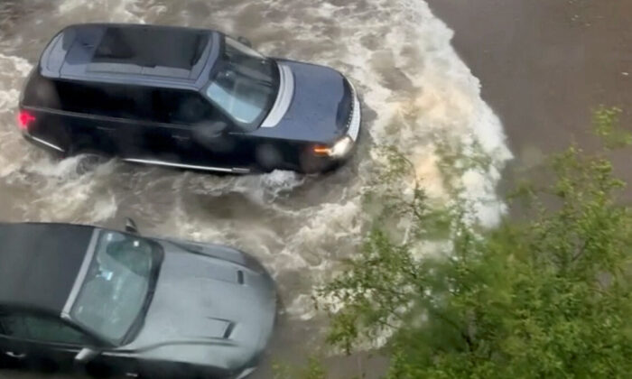 A car drives through a flooded street in Fort Worth, Texas, on Aug. 22, 2022, in this screen grab obtained from a social media video. (Fernando Garcia via Reuters)