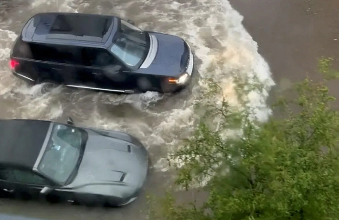 A car drives through a flooded street in Fort Worth, Texas, on Aug. 22, 2022, in this screen grab obtained from a social media video. (Fernando Garcia via Reuters)