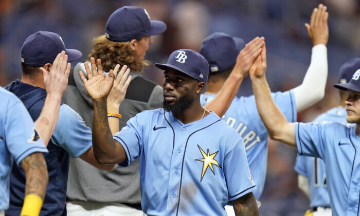 Tampa Bay Rays' Randy Arozarena, center, high fives teammates after the team defeated the Los Angeles Angels during a baseball game Monday, Aug. 22, 2022, in St. Petersburg, Fla. (Chris O'Meara/AP Photo)