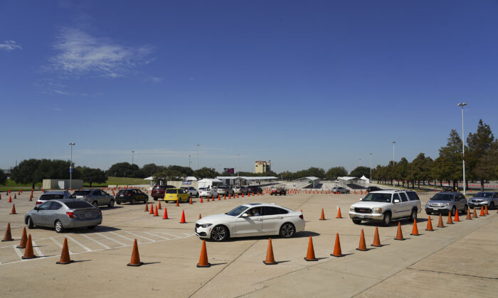 Voters in cars line up at a drive-through mail ballot drop-off site at NRG Stadium on Oct. 7, 2020 in Houston, Texas. (Photo by Go Nakamura/Getty Images) 