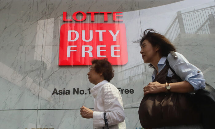 Pedestrians walk past signage for a Lotte Duty Free store in Seoul, South Korea, on Sept. 1, 2016. (Chung Sung-Jun/Getty Images)