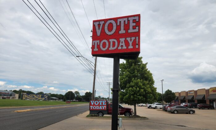 Signs at a shopping center encourage residents to vote in the state's GOP primary runoff elections in Muskogee, Okla., on Aug. 23, 2022. (Jeff Louderback/The Epoch Times)