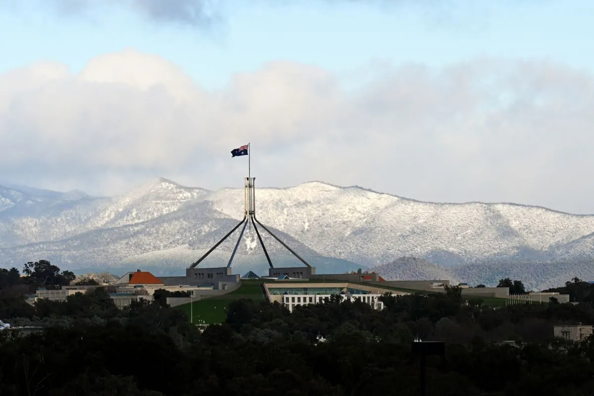 Snow covered hills are seen behind Parliament House in Canberra, Wednesday, June 1, 2022. (AAP Image/Lukas Coch