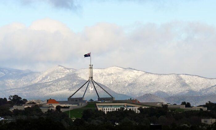 Snow covered hills are seen behind Parliament House in Canberra, Wednesday, June 1, 2022. (AAP Image/Lukas Coch