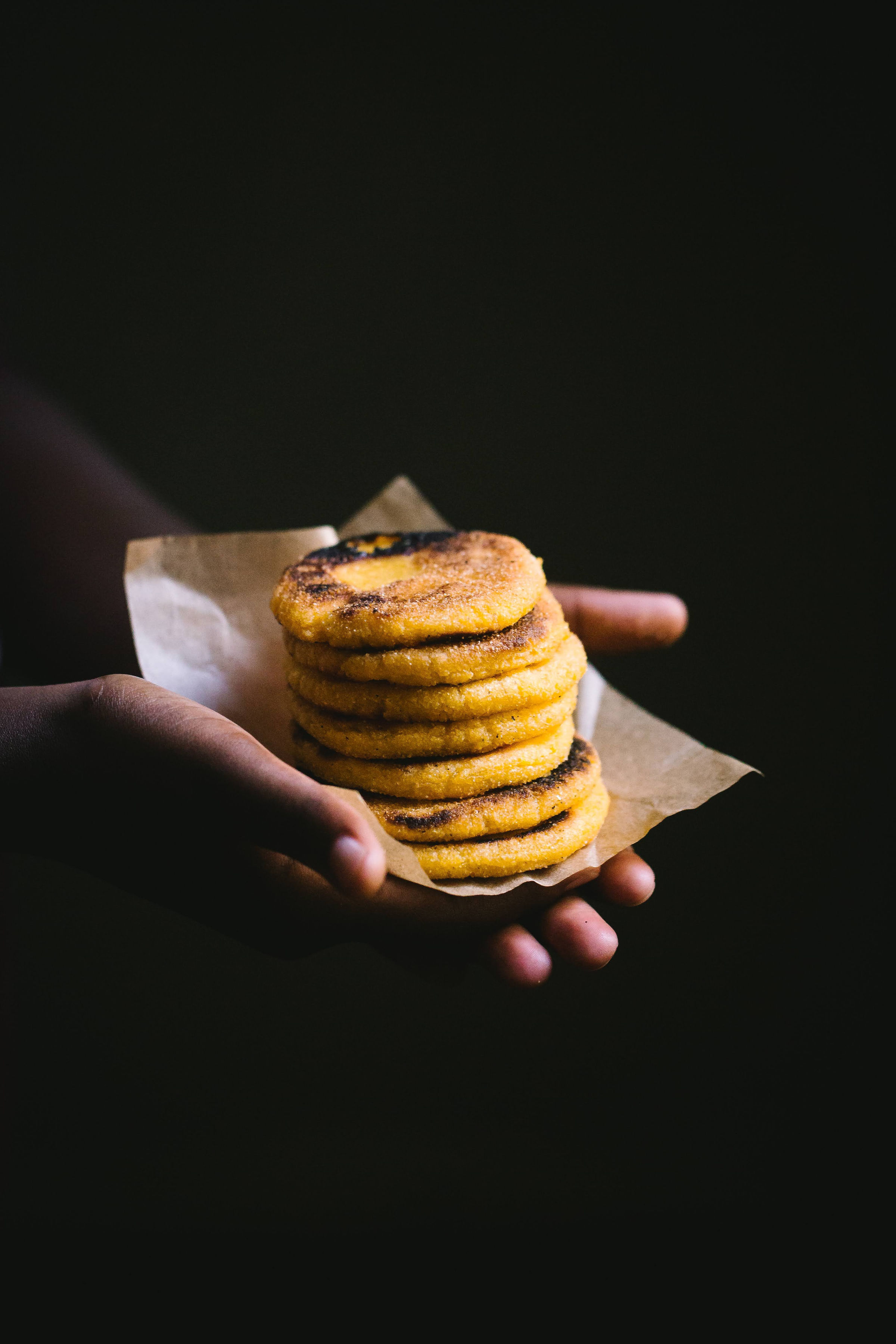 Arepas stacked in hand