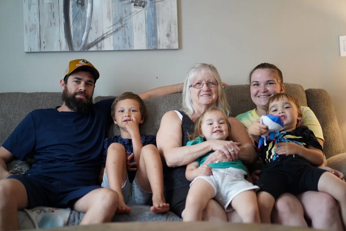 The Austin family (left to right: Joseph, Chandler, Autumn, Briana, and Weston) and Vivian Van Orden (M) sit on a couch in the living room at Van Orden's house in Port Jervis on Aug. 22, 2022. (Cara Ding/The Epoch Times)