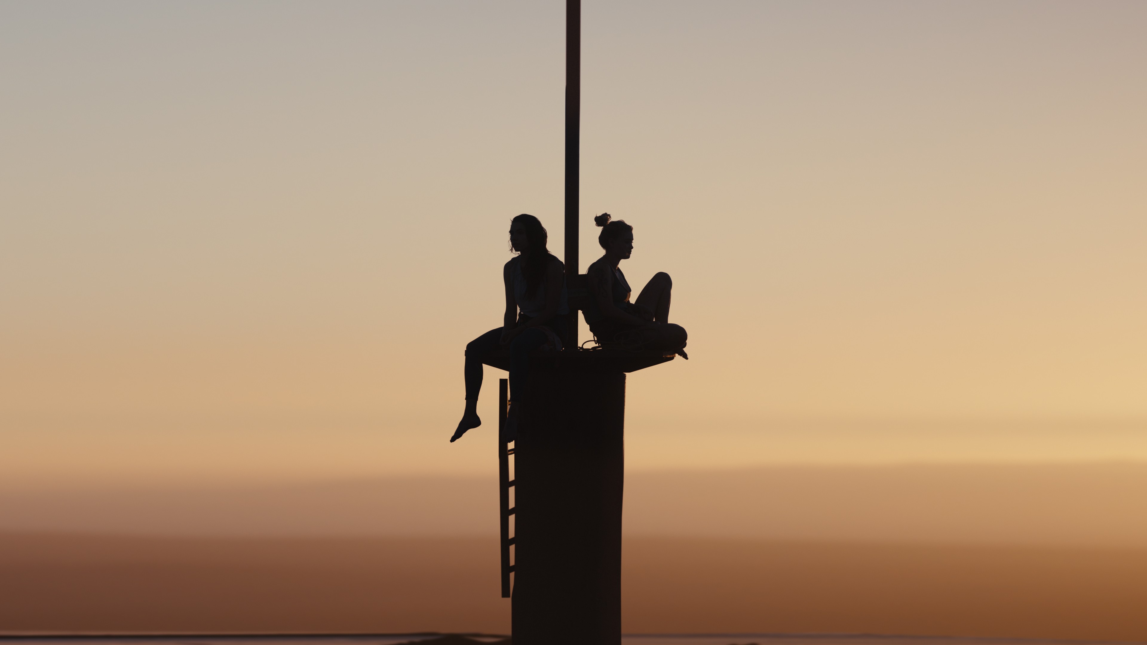 two women sit on an observation deck in FALL