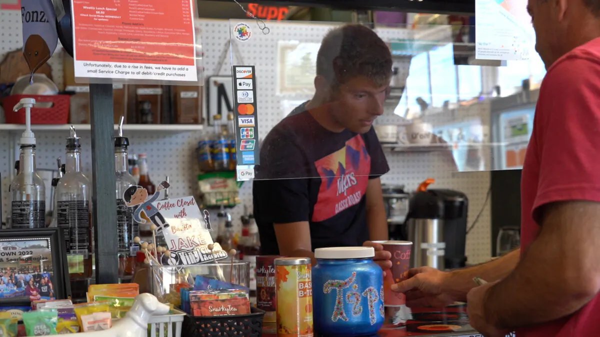 Barista Jake McFarland (left) says his coffee cart brings happiness to many people, including himself. (William Huang/The Epoch Times)