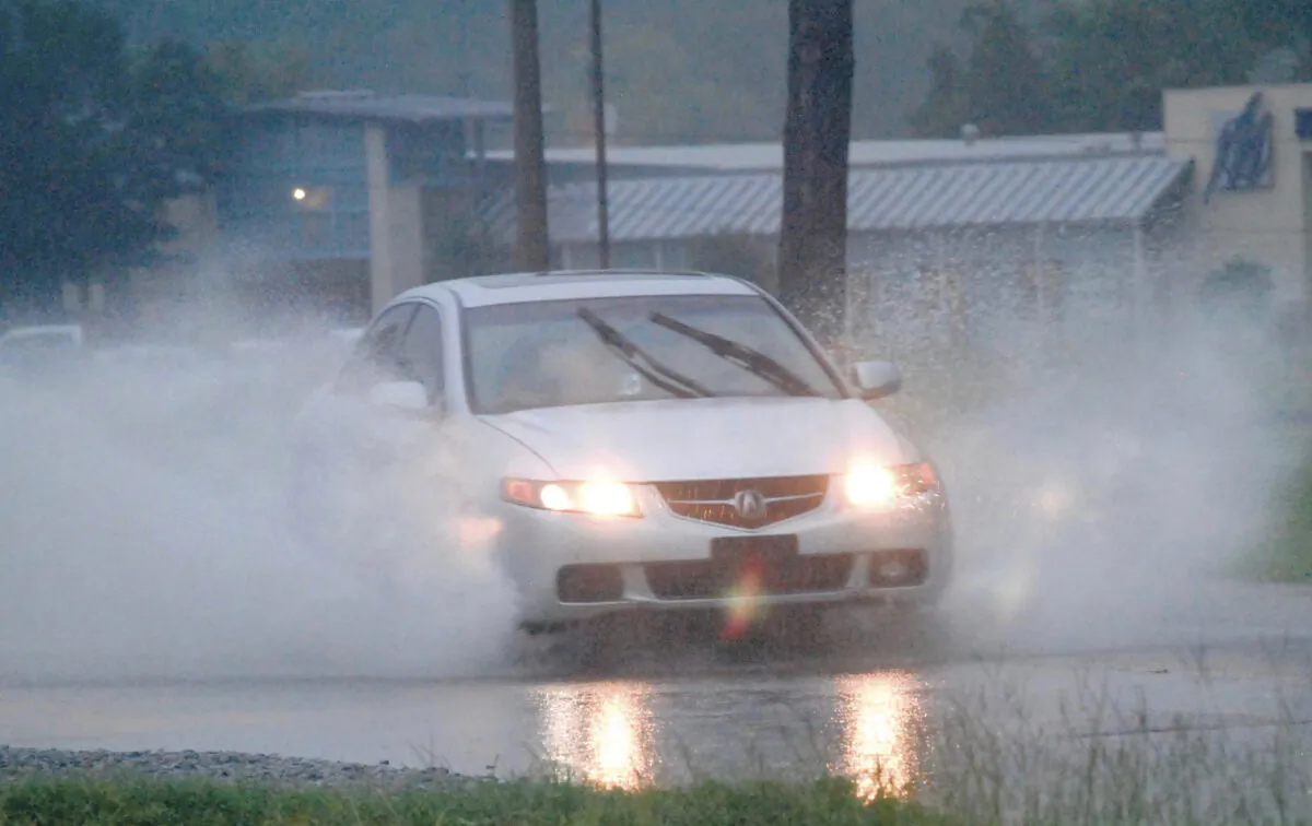 A driver drives through high water on Dale Drive in Marion, Miss., on Aug. 24, 2022. (D'Courtland Christian/The Meridian Star via AP)
