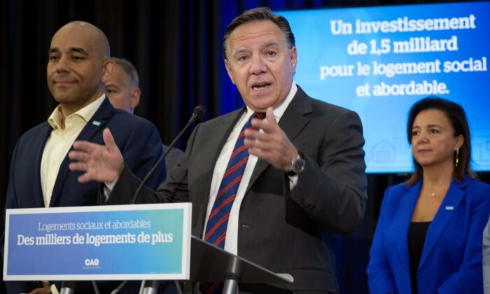 Quebec Premier François Legault, surrounded by CAQ candidates, speaks to the press in Laval, Que. on Aug. 12, 2022. (The Canadian Press/Peter McCabe)