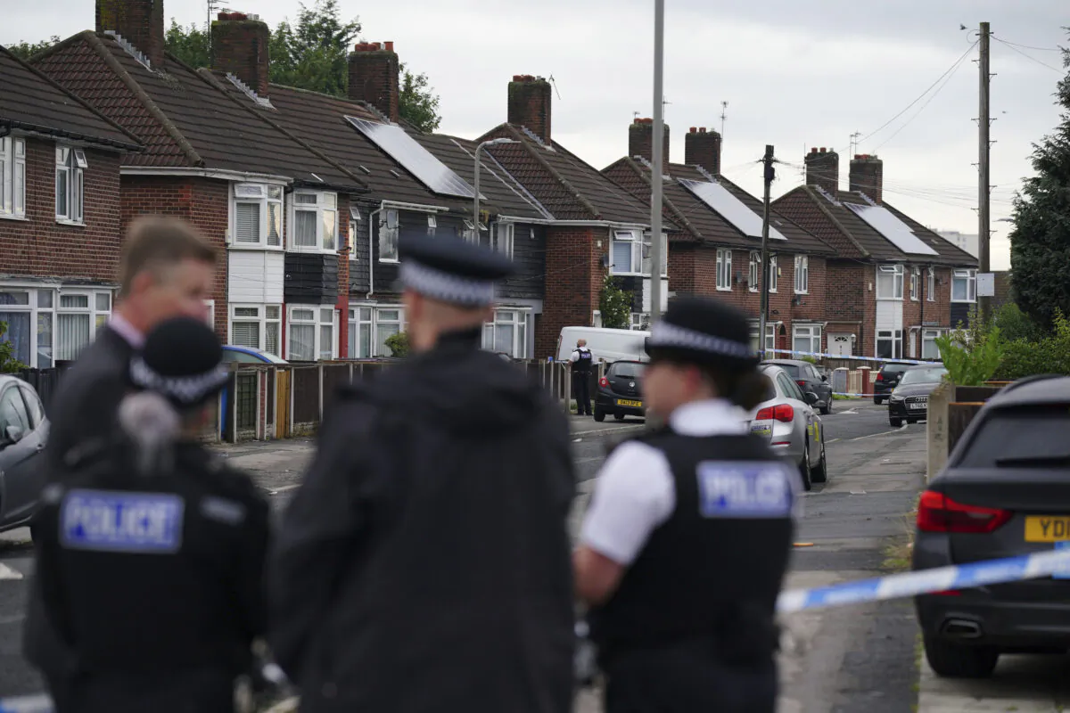 Police officers near the scene in Kingsheath Avenue, Knotty Ash, where a nine-year-old girl was fatally shot, in Liverpool, England, on Aug. 23, 2022. (Peter Byrne/PA via AP)
