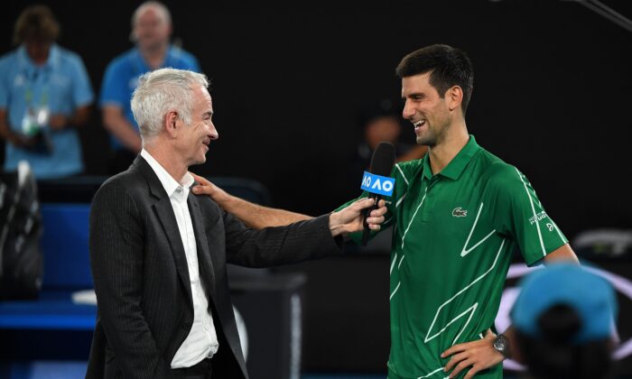 Former U.S. tennis player John McEnroe (L) interviews Serbia's Novak Djokovic after his victory against Germany's Jan-Lennard Struff in their men's singles match on day one of the Australian Open tennis tournament in Melbourne on Jan. 20, 2020. (William West/AFP via Getty Images)