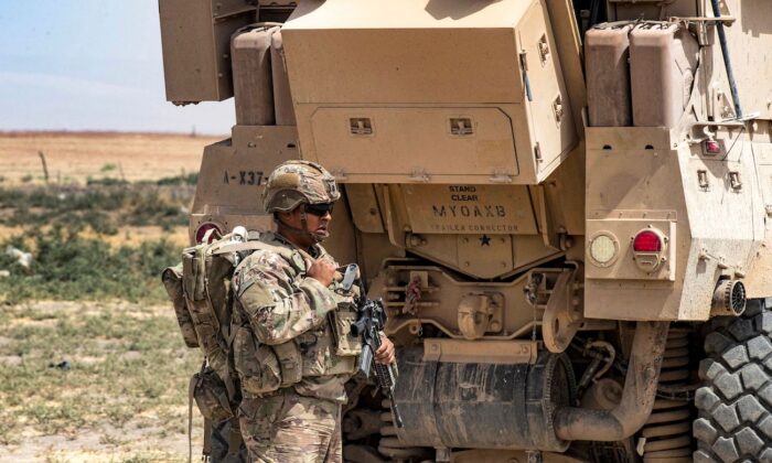 A U.S. soldier stands by a military vehicle in Syria's northeastern Hasakah province on Aug. 21, 2022. (Delil Souleiman/AFP via Getty Images)