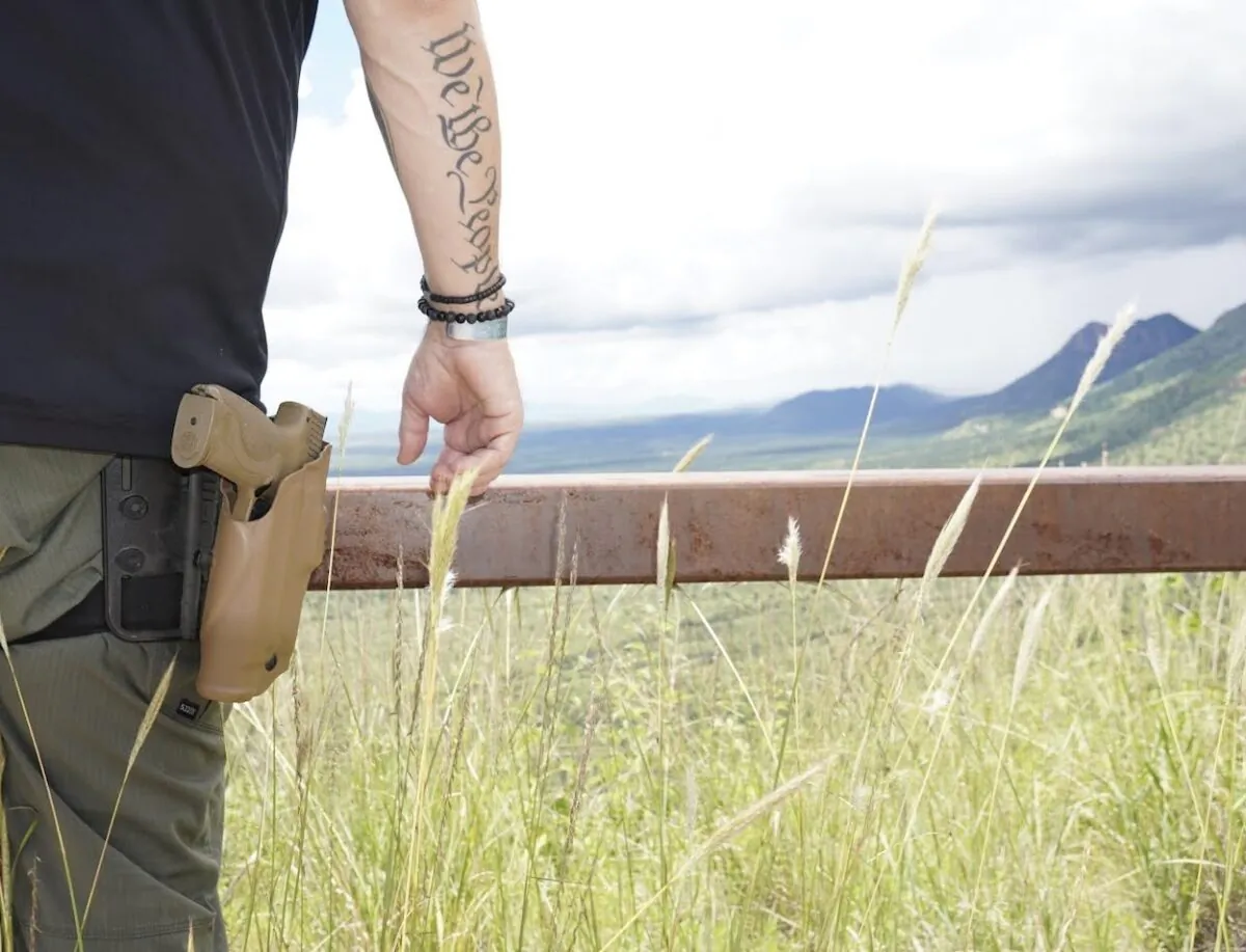 Sam, owner of a high-tech security company in Arizona, stands watch over the Mexican border from the summit of the Coronado National Memorial in Arizona. (Allan Stein/The Epoch Times)