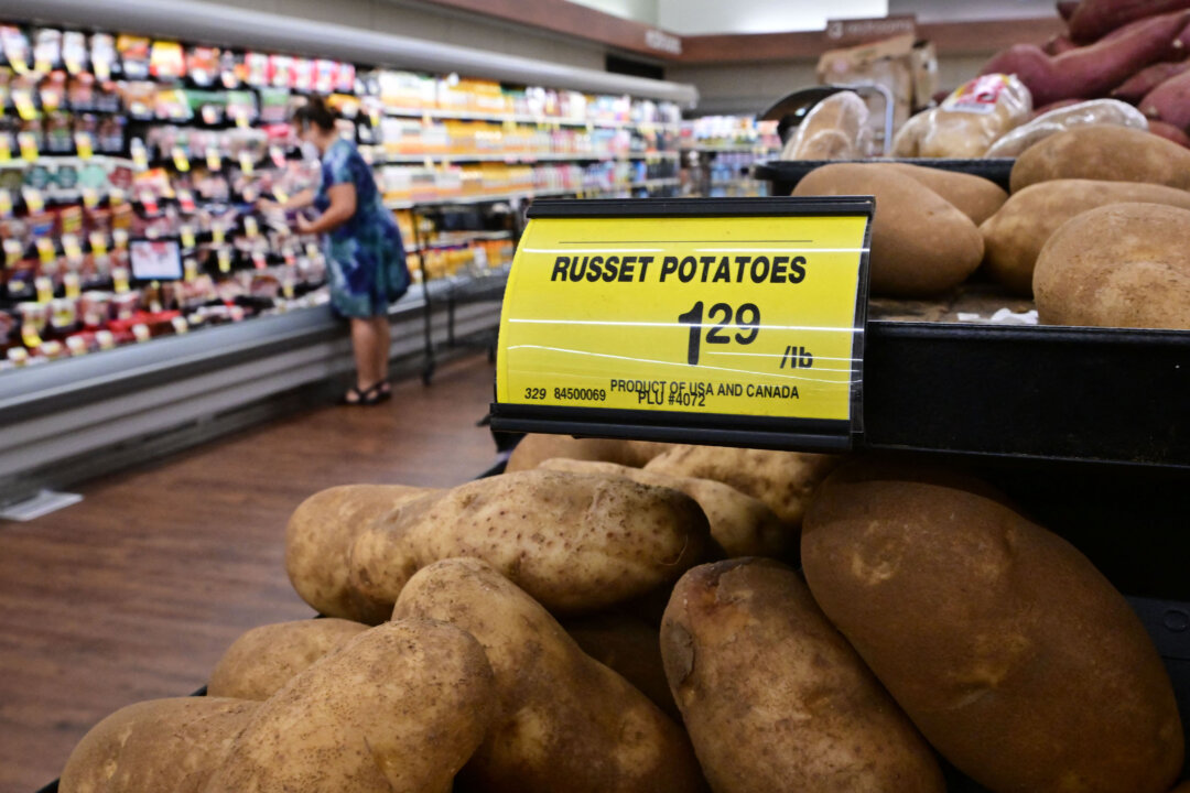 A shopper is seen past a sign displaying the price per pound of russet potatoes at a supermarket in Montebello, Calif., on Aug. 23, 2022. (Frederic J. Brown/AFP via Getty Images)