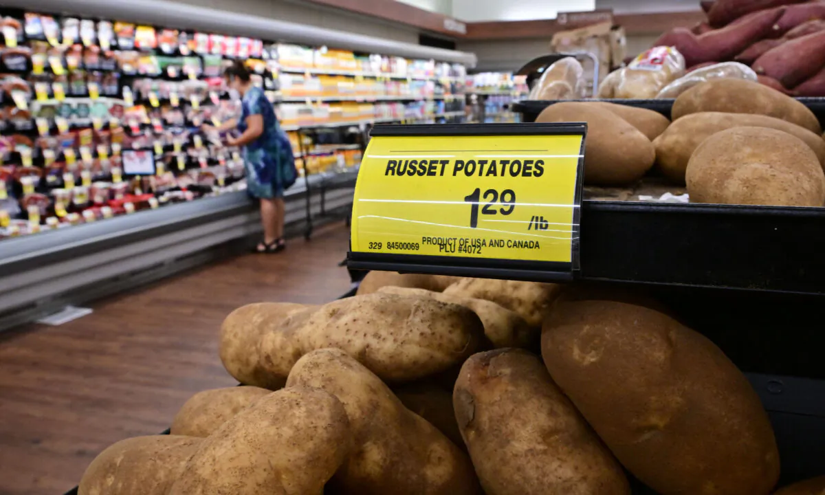 A shopper is seen past a sign displaying the price per pound of russet potatoes at a supermarket in Montebello, Calif., on Aug. 23, 2022. (Frederic J. Brown/AFP via Getty Images)