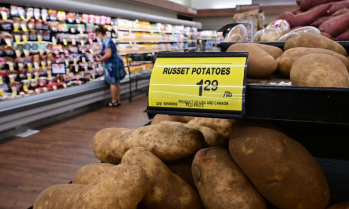 A shopper is seen past a sign displaying the price per pound of russet potatoes at a supermarket in Montebello, Calif., on Aug. 23, 2022. (Frederic J. Brown/AFP via Getty Images)