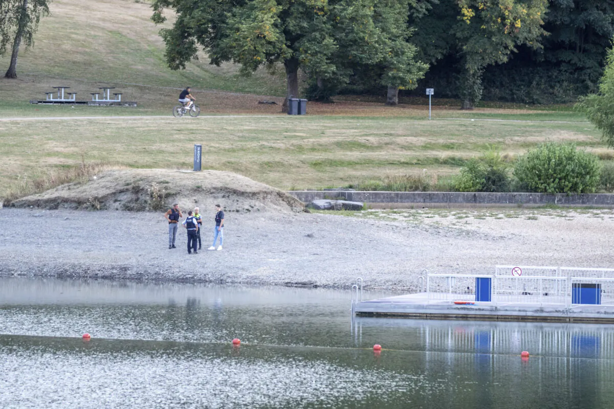 Policer officers stand on the shores of Lake Eiserbach near Aachen, Germany, on Aug, 26, 2022. (Ralf Roeger/dpa via AP)