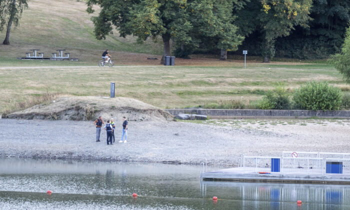 Policer officers stand on the shores of Lake Eiserbach near Aachen, Germany, on Aug, 26, 2022. (Ralf Roeger/dpa via AP)