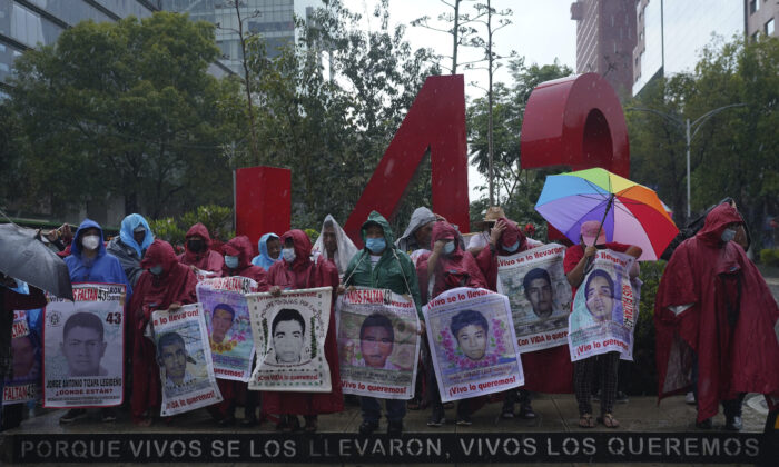 Friends and relatives seeking justice for the missing 43 Ayotzinapa students gather round a monument dedicated to the students during a demonstration in Mexico City on Aug. 26, 2022. (Marco Ugarte/AP Photo)