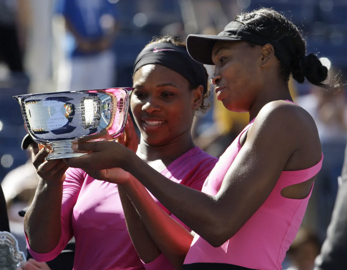 Serena Williams (L) of the United States and her sister Venus examine the championship trophy after winning the women's doubles championship over Cara Black of Zimbabwe and Liezel Huber of the United States at the U.S. Open tennis tournament in New York, on Sept. 14, 2009. (Darron Cummings/AP Photo)