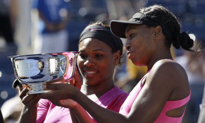 Serena Williams (L) of the United States and her sister Venus examine the championship trophy after winning the women's doubles championship over Cara Black of Zimbabwe and Liezel Huber of the United States at the U.S. Open tennis tournament in New York, on Sept. 14, 2009. (Darron Cummings/AP Photo)