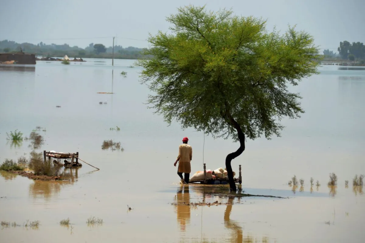 A villager uses cots to save usable items after salvaging from his flood-hit home, in Jaffarabad, a district of Pakistan's southwestern Baluchistan Province, on Aug. 27, 2022. (Zahid Hussain/AP Photo)