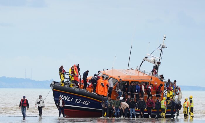A group of illegal immigrants are brought in to Dover, England, by the Royal National Lifeboat Institute, on Aug. 25, 2022. (Gareth Fuller/PA Media)