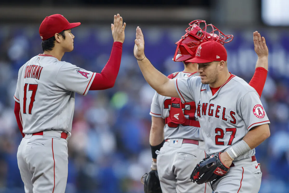 Shohei Ohtani #17 and Mike Trout #27 of the Los Angeles Angels celebrate their MLB game victory against the Toronto Blue Jays, among teammates, at the Rogers Centre in Toronto, Canada, August 27, 2022. (Cole Burston/Getty Images)
