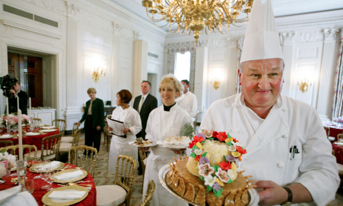 White House pastry chef Roland Mesnier (R) displays a mango coconut lei, the dessert for the dinner hosted by President George W. Bush for Philippine President Gloria Macapagal Arroyo, in the State Dining Room in the White House on May 19, 2003. (Charles Dharapak/AP Photo)