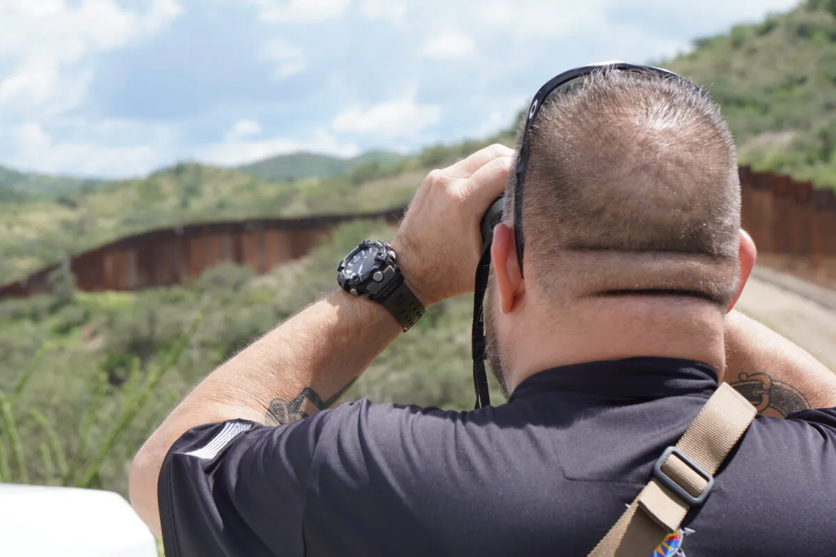 Sam, owner of a high-tech security company in Arizona, scans the southern border wall fence for illegal smuggling activity on Aug. 25, 2022. (Allan Stein/The Epoch Times)
