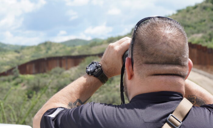Sam, owner of a high-tech security company in Arizona, scans the southern border wall fence for illegal smuggling activity on Aug. 25, 2022. (Allan Stein/The Epoch Times)