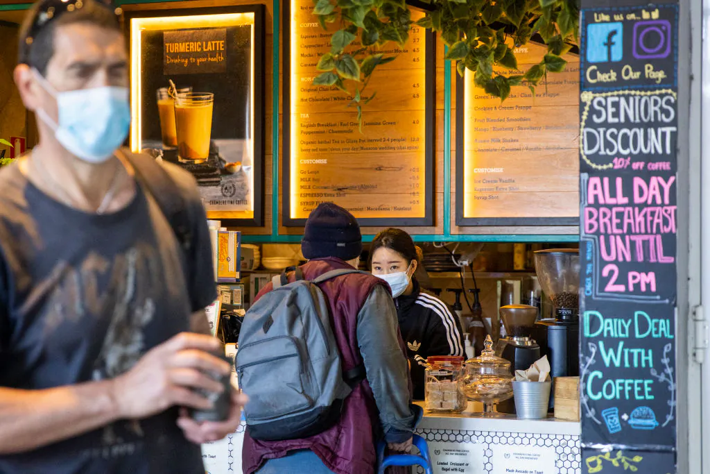 A woman takes orders in a Burwood Plaza coffee shop, open for take-away items in Sydney, Australia, on Aug. 12, 2021. (Jenny Evans/Getty Images)