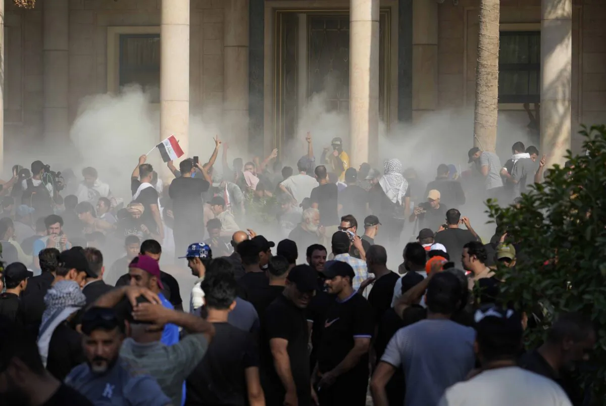 Iraqi security forces fire tear gas on the followers of Shiite cleric Muqtada al-Sadr inside the government Palace in Baghdad on Aug. 29, 2022. (Hadi Mizban/AP Photo)