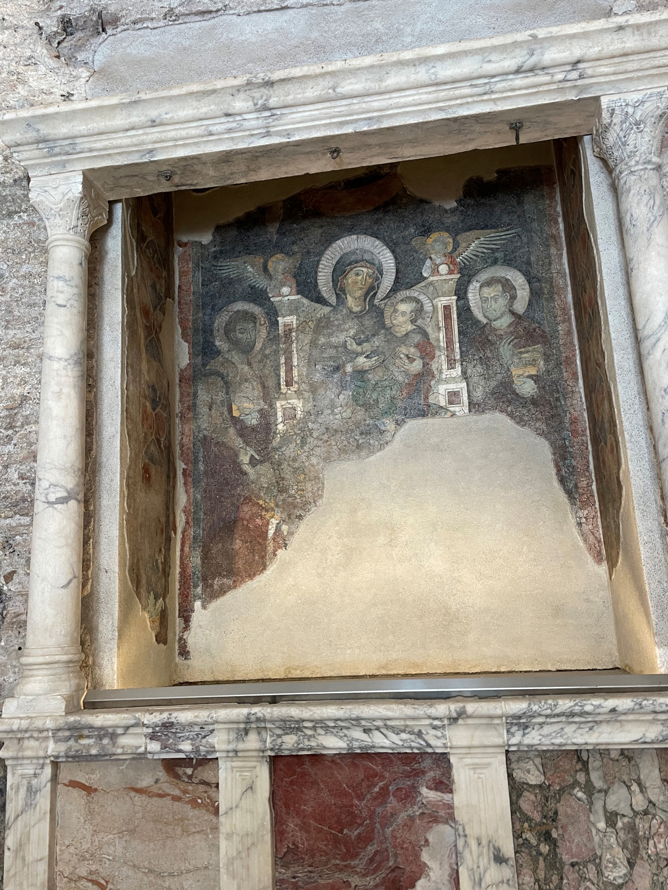 Ancient metal hooks for pagan rituals peek out above a repurposed Christian altar in the Roman Forum.