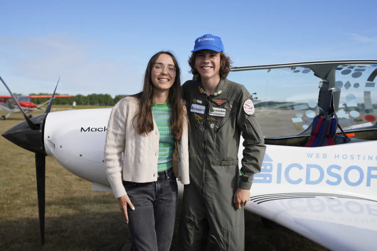 Seventeen year old Anglo-Belgian pilot Mack Rutherford (R) poses with his sister Zara Rutherford after landing at the Buzet airfield in Pont-A-Celles, Belgium, on Aug. 23, 2022. (Virginia Mayo/AP Photo)