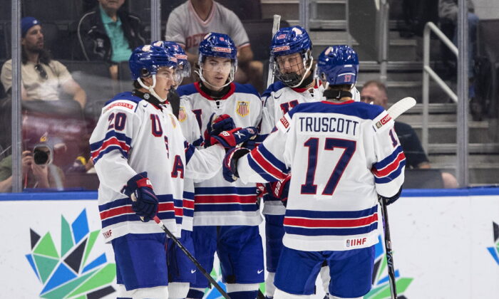 United States' Red Savage (20), Riley Duran (8), Charlie Stramel (23) and Jacob Truscott (17) celebrate a goal against Austria during the first period of an IIHF World Junior Hockey Championship game in Edmonton, Alberta, Canada, on Aug. 13, 2022. (Jason Franson/The Canadian Press via AP)