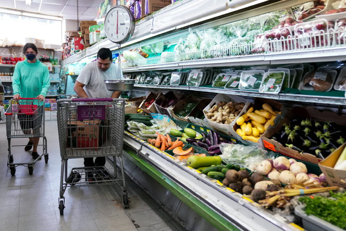 A man arranges produce at Best World Supermarket in the Mount Pleasant neighborhood of Washington on Aug. 19, 2022. (Sarah Silbiger/Reuters)