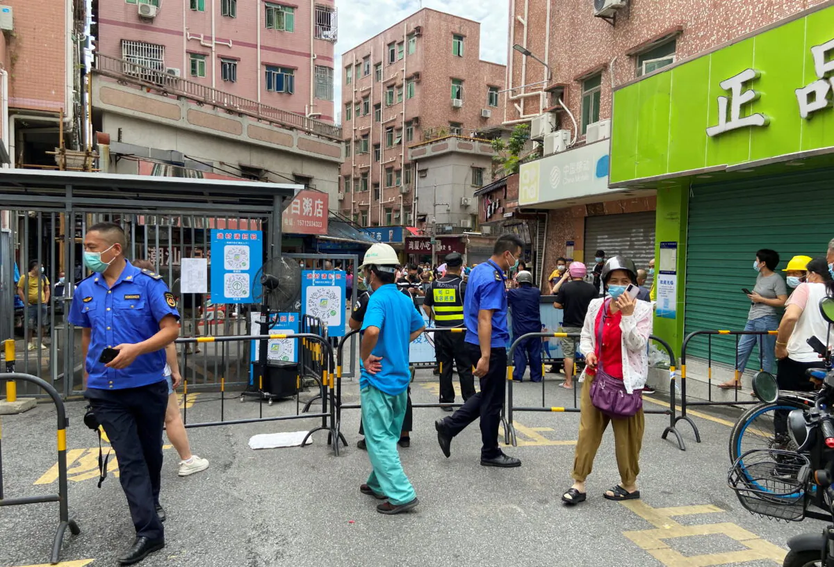 Security guards stand at an entrance to Wanxia urban village, which has been closed as part of COVID-19 measures in Shenzhen, Guangdong Province, China, on Aug. 29, 2022. (David Kirton/Reuters)